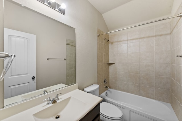 full bathroom featuring tiled shower / bath, vanity, toilet, and lofted ceiling