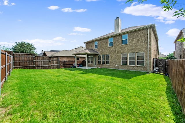 back of property with a yard and a patio