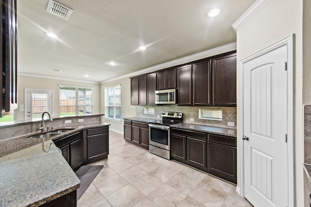 kitchen with dark brown cabinetry, sink, tasteful backsplash, crown molding, and appliances with stainless steel finishes