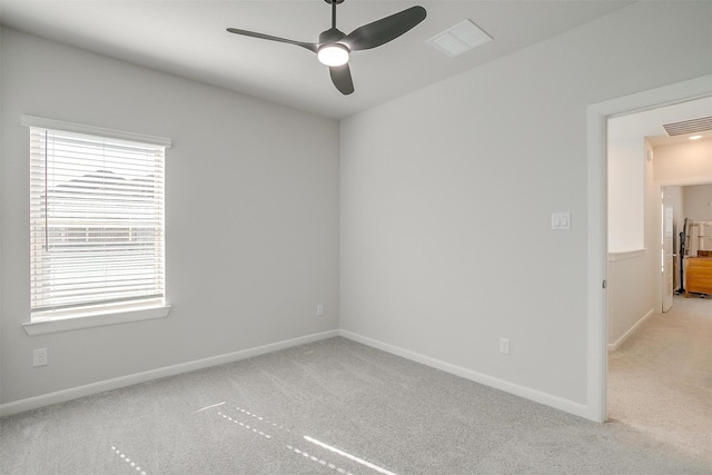 spare room featuring light carpet and ceiling fan