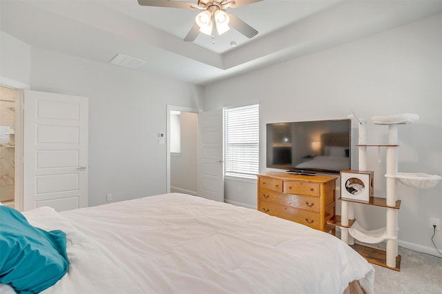 carpeted bedroom featuring a raised ceiling and ceiling fan