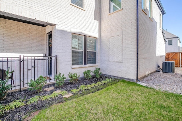 view of property exterior with central AC unit and a lawn