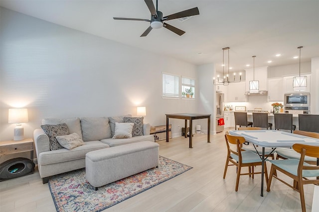 living room featuring ceiling fan and light wood-type flooring