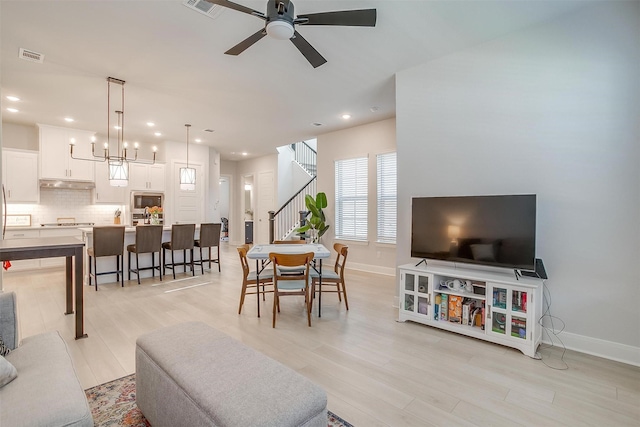 living room with ceiling fan and light hardwood / wood-style flooring