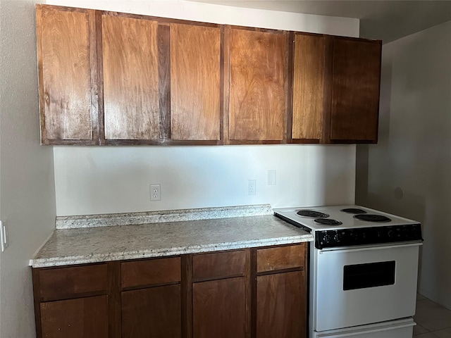 kitchen featuring light stone counters and white range with electric cooktop