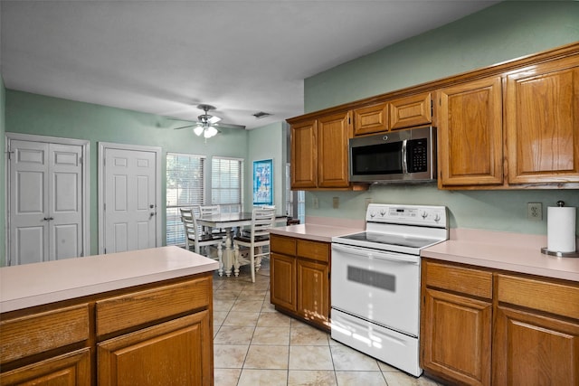 kitchen with white electric stove, light tile patterned floors, and ceiling fan