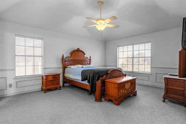 bedroom with multiple windows, light carpet, and ceiling fan