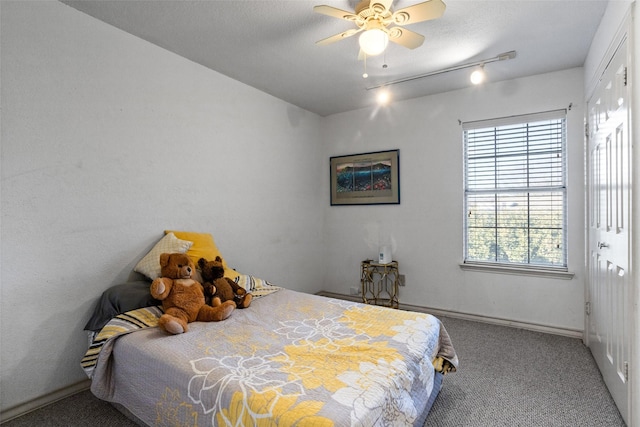 bedroom with ceiling fan, carpet floors, and a textured ceiling