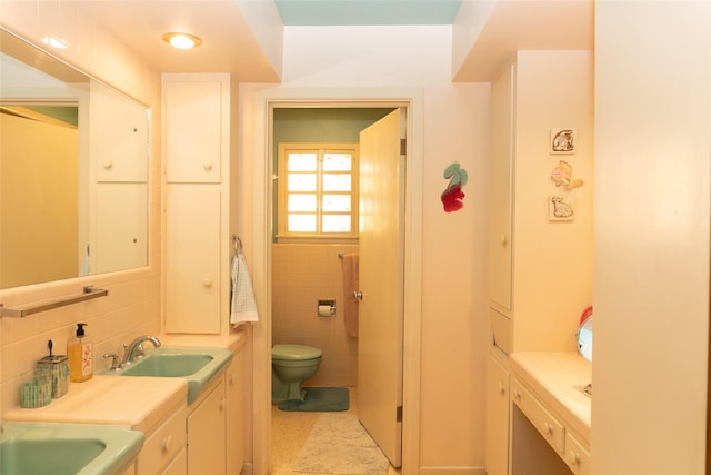 bathroom with vanity, tile walls, and toilet