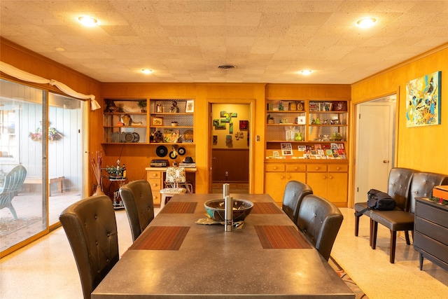 dining space with built in shelves and wood walls