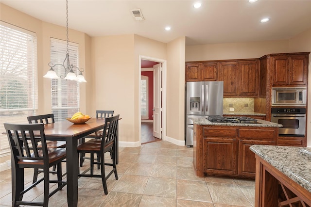 kitchen featuring appliances with stainless steel finishes, a chandelier, recessed lighting, decorative backsplash, and baseboards