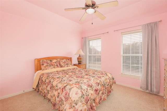 bedroom featuring light colored carpet, baseboards, and ceiling fan
