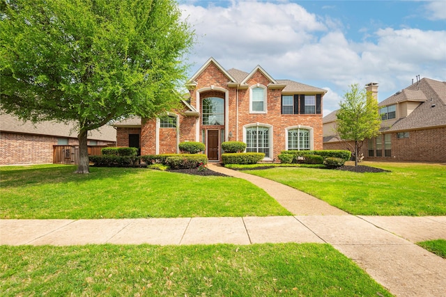 view of front of home featuring a front lawn and brick siding