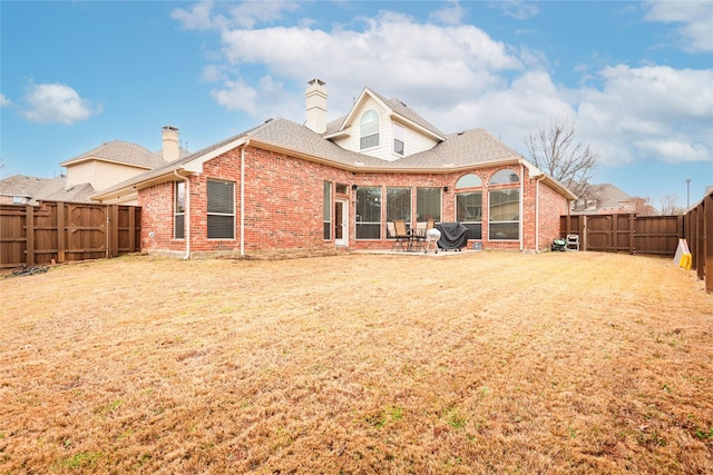 back of property featuring a patio, a fenced backyard, brick siding, a shingled roof, and a lawn