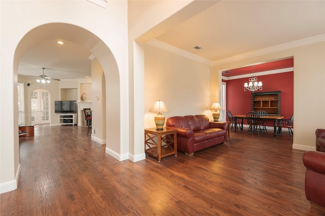 living room with ornamental molding, ceiling fan with notable chandelier, and dark hardwood / wood-style flooring