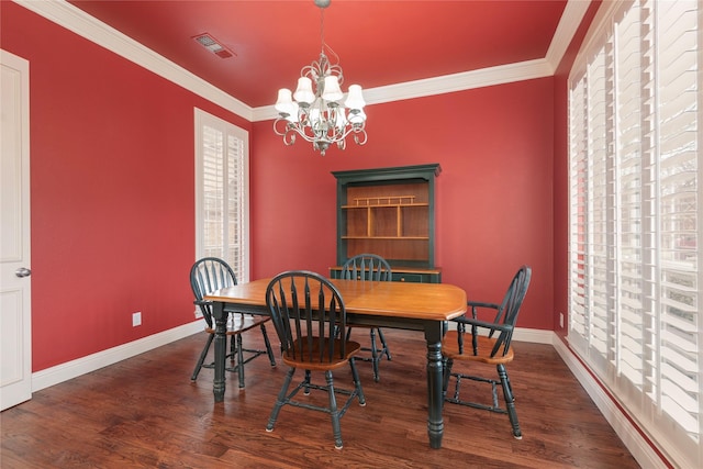 dining area featuring baseboards, visible vents, wood finished floors, an inviting chandelier, and crown molding