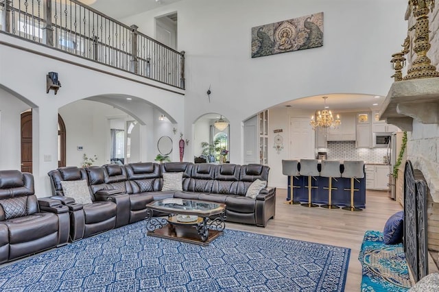 living room with an inviting chandelier and light wood-type flooring