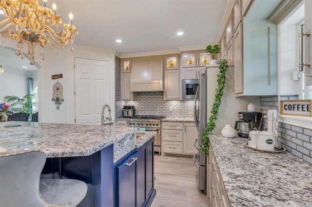 kitchen featuring appliances with stainless steel finishes, pendant lighting, light stone counters, custom range hood, and light wood-type flooring