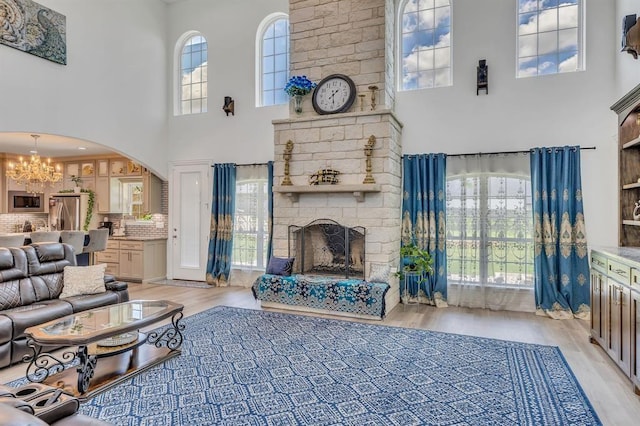 living room with a wealth of natural light, light hardwood / wood-style flooring, and a large fireplace