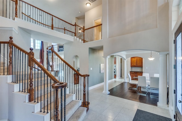 tiled entryway with ornate columns and a towering ceiling