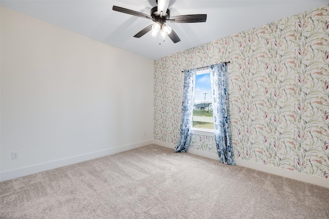 carpeted spare room featuring ceiling fan