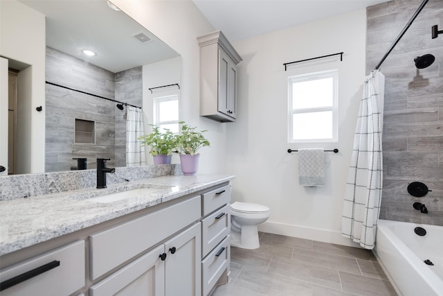 full bathroom featuring vanity, shower / tub combo, toilet, and a healthy amount of sunlight