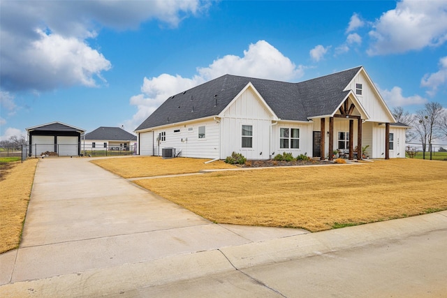 modern inspired farmhouse featuring a garage, an outbuilding, central AC unit, and a front lawn