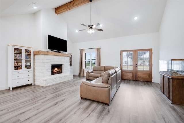 living room featuring a stone fireplace, high vaulted ceiling, beamed ceiling, light hardwood / wood-style flooring, and french doors