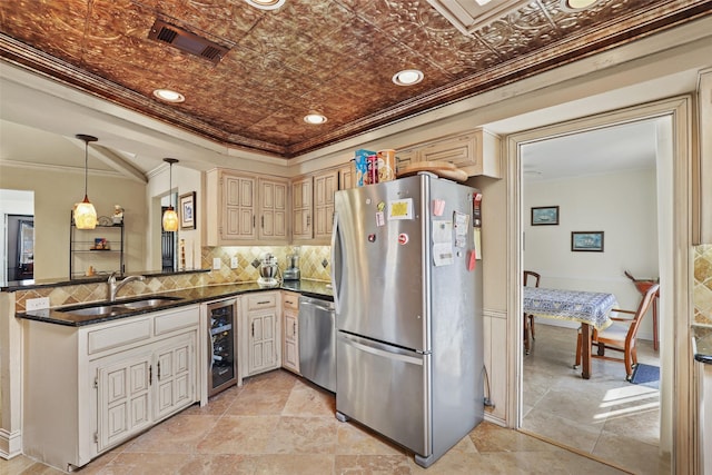 kitchen featuring pendant lighting, sink, crown molding, stainless steel appliances, and beverage cooler