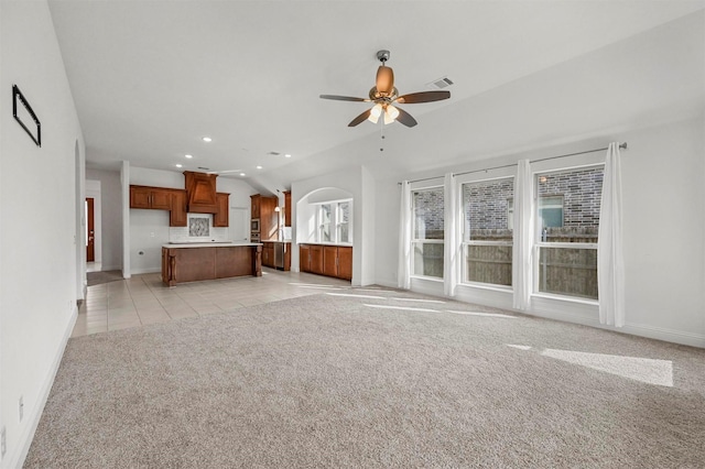 unfurnished living room with ceiling fan, light colored carpet, and lofted ceiling