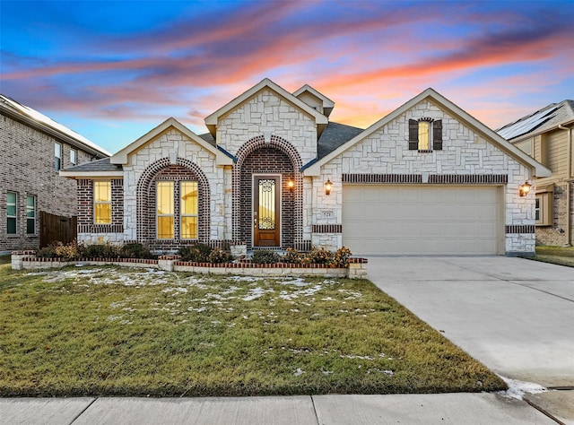 view of front of property with a garage and a yard