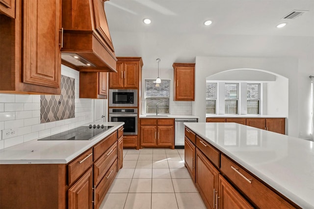 kitchen with appliances with stainless steel finishes, pendant lighting, decorative backsplash, custom exhaust hood, and light tile patterned floors