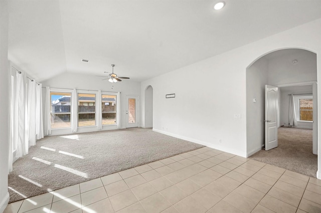 unfurnished living room featuring vaulted ceiling, light colored carpet, and ceiling fan