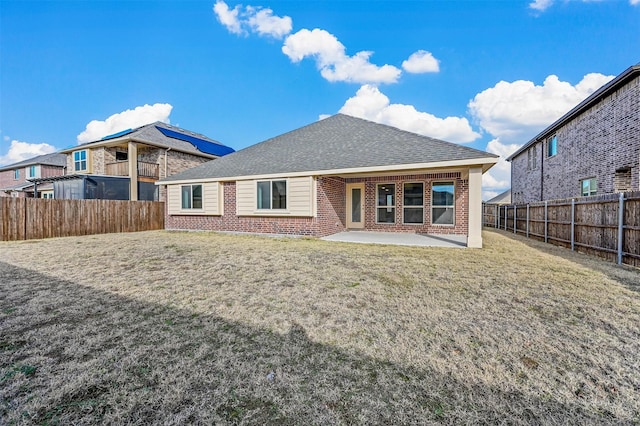 rear view of house with a yard and a patio