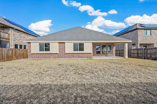 rear view of property featuring a patio area and a lawn