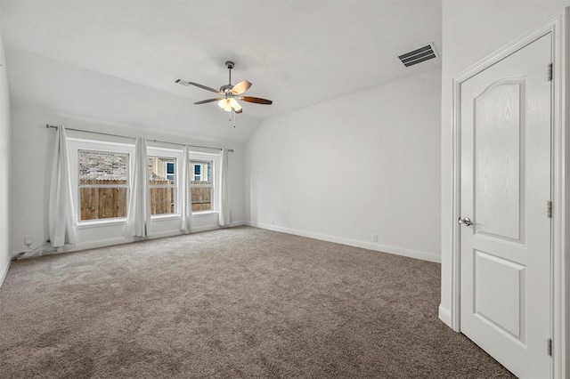 spare room featuring dark colored carpet, lofted ceiling, and ceiling fan