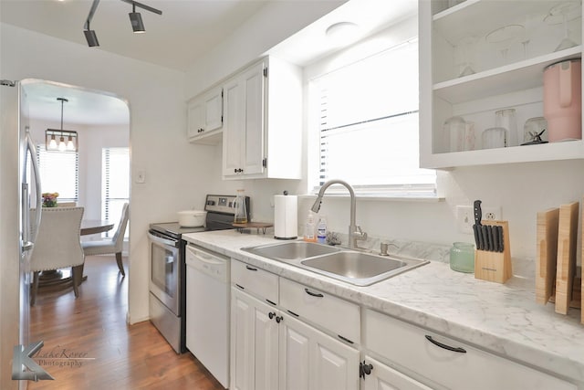 kitchen featuring white cabinetry, stainless steel appliances, sink, and pendant lighting