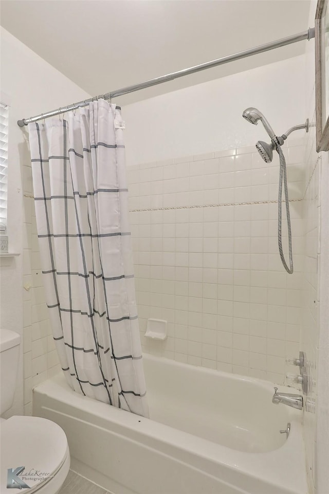 bathroom featuring shower / bath combination with curtain and toilet