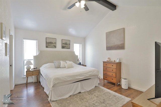 bedroom with multiple windows, wood-type flooring, ceiling fan, and lofted ceiling with beams