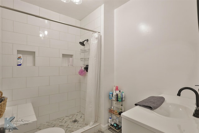 bathroom with sink, curtained shower, and toilet