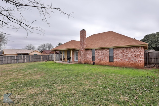 rear view of property with a yard and a patio area