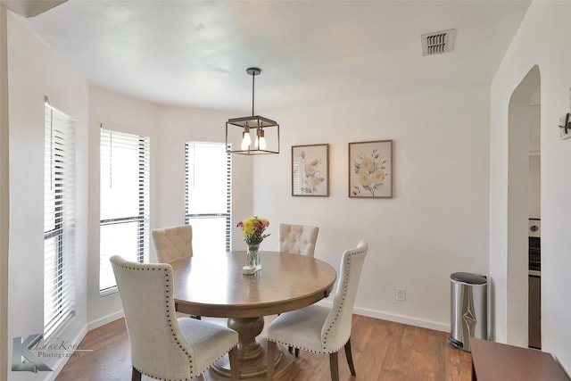 dining area with a notable chandelier and dark wood-type flooring