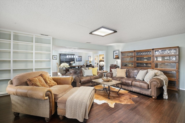 living room featuring dark wood-type flooring and a textured ceiling