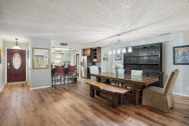 dining room featuring dark wood-type flooring and a textured ceiling