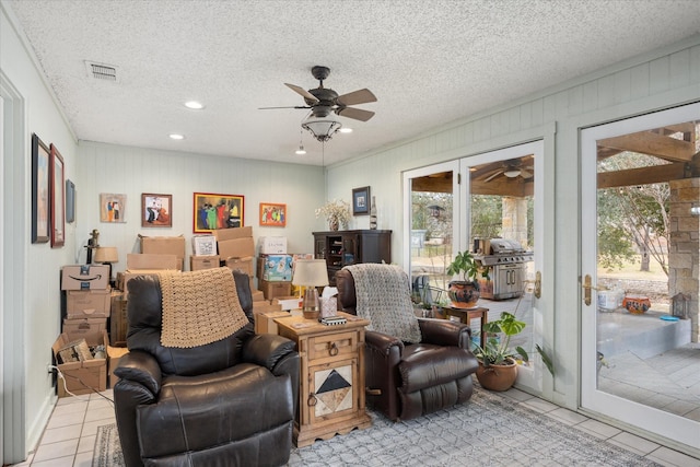 sitting room with light tile patterned floors, ceiling fan, visible vents, and a textured ceiling