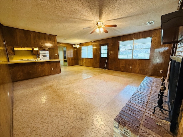 living area featuring a healthy amount of sunlight, visible vents, and wooden walls