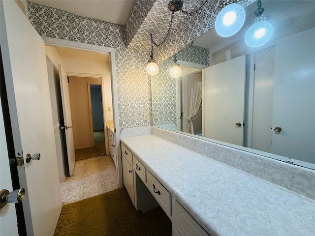 bathroom featuring vanity and wallpapered walls