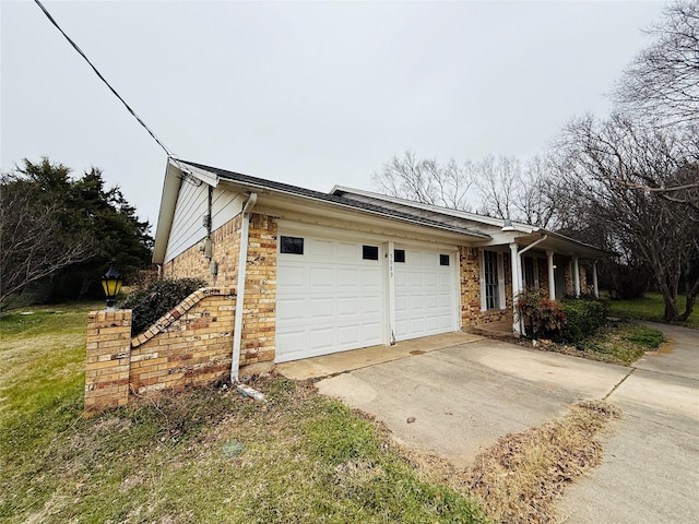 view of property exterior with a garage, driveway, and brick siding