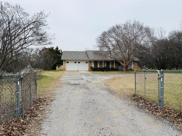 single story home with an attached garage, brick siding, gravel driveway, and fence