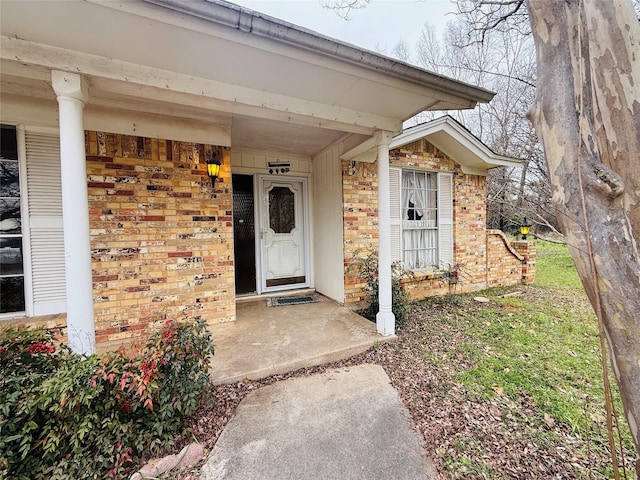 entrance to property featuring brick siding